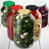 A collection of glass jars filled with preserved food items, such as pickles, red cabbage, and apples, arranged on a wooden surface. Podgląd zdjęcia produktu