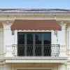 A brown awning is installed above a balcony door on a building. Podgląd zdjęcia produktu