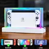 A Nintendo Switch OLED model is displayed in a white dock with colorful LED lighting. Below, three different Nintendo Switch models are shown with compatibility indicators. Produktbild-Vorschau
