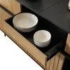 A close-up view of an open drawer in a wooden cabinet, revealing white bowls and plates. Produktbild-Vorschau