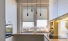 A modern kitchen with a large window overlooking a city. Produktbild-Vorschau