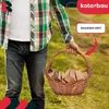 A person is holding a wicker basket filled with firewood. Náhľad obrázku produktu