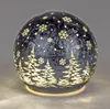 A decorative LED glass ball with a winter forest and snowflake design. Produktbild-Vorschau