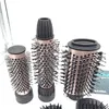 Three different sized cylindrical hair styling brush attachments with black bristles and rose gold barrels are arranged on a white background. Anteprima dell’immagine prodotto