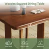 A close-up of a wooden dining table with text overlays highlighting its features. Voir les images du produit