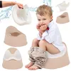 A young boy is sitting on a potty training seat, surrounded by various potty training products. Water splashes are depicted around one of the products. Produktbild-Vorschau