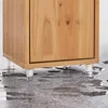 Close-up of the bottom of a wooden cabinet with clear legs standing on a wet floor. Produktbild-Vorschau