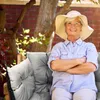 An elderly woman sits on a cushioned bench in a garden. Náhled obrázku produktu