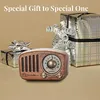 A vintage-style radio is placed in front of two wrapped gifts, suggesting it's a gift. Produktbild-Vorschau