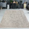 A vintage-style beige rug is placed on a light gray floor in a modern room with a desk and shelving unit in the background. Produktbild-Vorschau