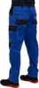 A person wearing blue work pants with black accents and black and red shoes. Produktbild-Vorschau