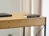 A close-up view of a wooden desk with a laptop and a book on it. Náhled obrázku produktu