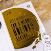 A close-up of an open advent calendar with a gold decorative element featuring holiday wishes. Produktbild-Vorschau