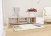 A TV lowboard with open compartments and doors, placed in a living room setting with a rug in front of it. Produktbild-Vorschau