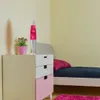 A lava lamp and a potted plant sit on a nightstand next to a bed. Produktbild-Vorschau
