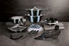 A collection of cookware and kitchen utensils arranged on a textured surface against a dark, slate-like background. Podgląd zdjęcia produktu