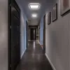 A modern hallway with dark doors and two illuminated ceiling lights. Voir les images du produit