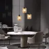 A dining room setting with a marble table, chairs, and pendant lights. Produktbild-Vorschau
