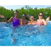 Four people are enjoying themselves in a swimming pool, holding drinks. Produktbild-Vorschau