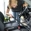 A woman is vacuuming the interior of a car. Anteprima dell’immagine prodotto