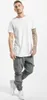 A man is standing and posing in a studio setting against a white background, wearing a white t-shirt and gray cargo pants. Produktbild-Vorschau