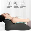 A woman is lying on her back on a bed, using a black ergonomic pillow for her neck and head. The image has overlaid graphics and text highlighting product features. Produktbild-Vorschau