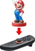 A Nintendo Amiibo figure of Mario is shown above a Nintendo Joy-Con controller, with a red arrow indicating that the Amiibo can be placed on the controller. Produktbild-Vorschau