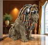 A decorative lion sculpture with dreadlocks and headphones sits in a well-decorated room with a large window. Produktbild-Vorschau
