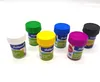 Six small jars of tempera paint in various colors are arranged on a white surface. Produktbild-Vorschau