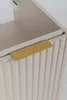 Close-up of a cabinet door with a ribbed texture and a gold handle. Produktbild-Vorschau