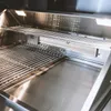 Close-up view of the interior of a stainless steel gas grill. Podgląd zdjęcia produktu