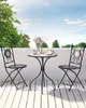 A bistro set on a balcony with trees and sky in the background. Podgląd zdjęcia produktu
