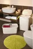 A bathroom scene with a sink, toilet, laundry baskets, and a rug. Produktbild-Vorschau