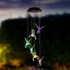 A solar-powered wind chime with hummingbird-shaped lights hanging outdoors at dusk. Voir les images du produit