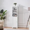 A tall, white cabinet with shelves and a door, decorated with a few items, stands in a room with a plant and furniture. Produktbild-Vorschau
