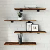 Four wooden shelves mounted on a white brick wall, decorated with a plant, two framed pictures, and a cup of pencils. Produktbild-Vorschau