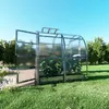 A greenhouse with plants inside, set in a grassy yard with trees in the background. Produktbild-Vorschau