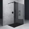 A modern walk-in shower with black fixtures and tinted glass, set against a concrete wall. Produktbild-Vorschau