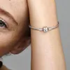 A close-up shot of a person's arm wearing a Pandora bracelet with a charm. Podgląd zdjęcia produktu