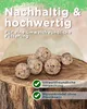 Birdseed balls are displayed on a tree stump, with green and brown abstract background elements. Produktbild-Vorschau