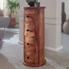 A wooden cabinet with drawers is placed on a rug in a room with a plant and a chair. Produktbild-Vorschau