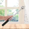 A hand holding a window opening lever in front of a window with curtains. Produktbild-Vorschau