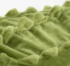 A close-up shot of a green plush fabric with raised, bumpy textures. Podgląd zdjęcia produktu