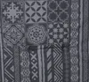 A close-up view of a patterned fabric, likely a cushion or mattress topper, with geometric and tribal-inspired designs in shades of gray. Produktbild-Vorschau