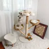 Two cats playing on a multi-level cat tree with baskets and a plush stool nearby. Produktbild-Vorschau