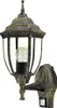 A close-up studio shot of a gold and black outdoor wall lantern with a clear glass enclosure and a visible light bulb. Produktbild-Vorschau