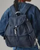A person wearing a denim jacket and jeans, with a blue canvas backpack on their back. Voir les images du produit
