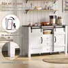 A white buffet cabinet with sliding barn doors and drawers, decorated with kitchen items on top and a rug on the floor. Voir les images du produit
