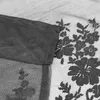 A close-up view of black lace fabric with a floral pattern. Produktbild-Vorschau