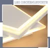 A close-up view of a modern, geometric LED ceiling light with a warm, diffused glow. Produktbild-Vorschau
